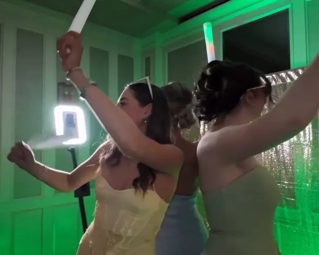 Friends with arms in the air under green lights